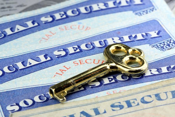 A gold key atop a social security card.