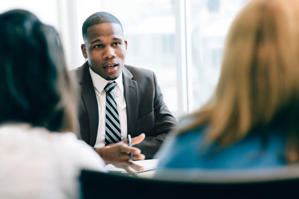 Businessperson giving advice to two clients.