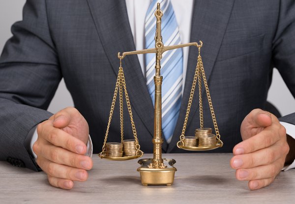 Businessperson with scale weighing coins.