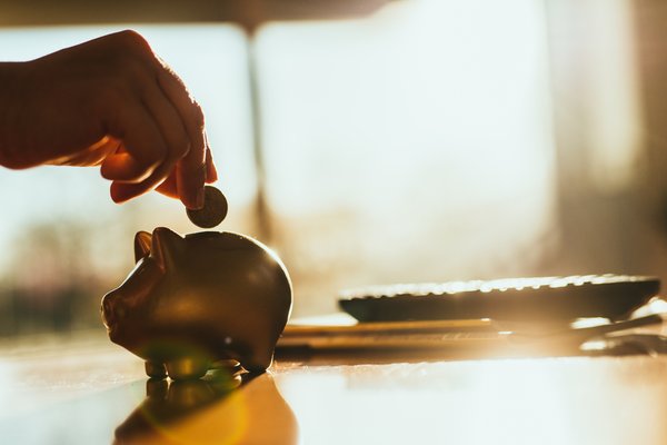 Putting coin in piggy bank.