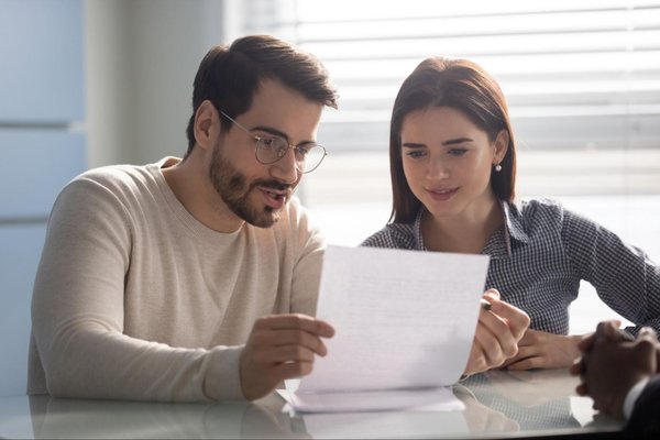 Two people look at document together at a table.