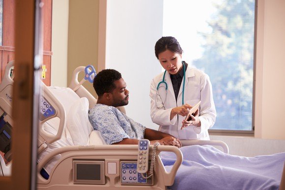 Doctor discusses info on a tablet with patient.