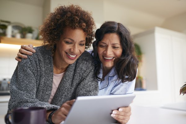 Two people reviewing finances on tablet.