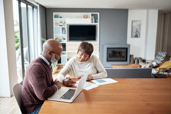 older couple at dining table going over paperwork