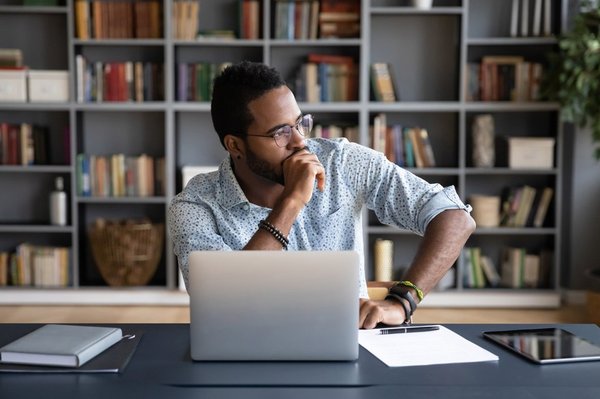 A man sitting in front of a laptop.