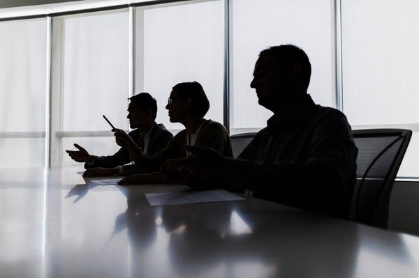 The silhouettes of a board of directors.