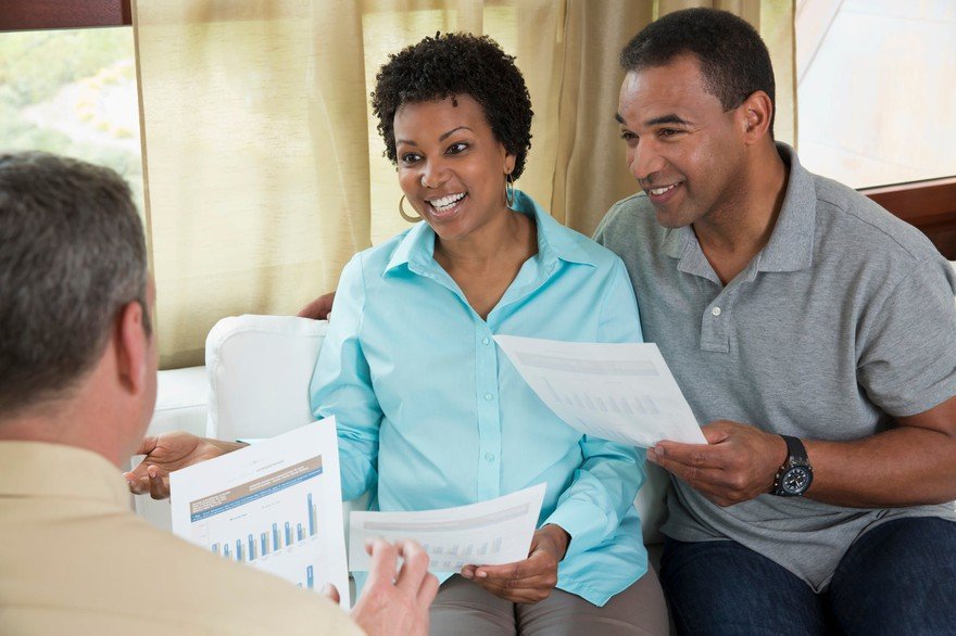 A couple discussing stocks with a man. 