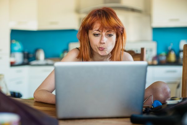 Person looking at laptop and thinking.