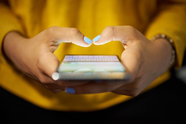 Hands hold a cell phone.