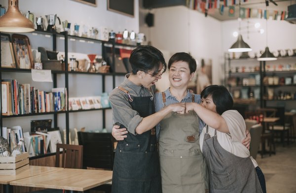 Three people in a small mom-and-pop retail shop.