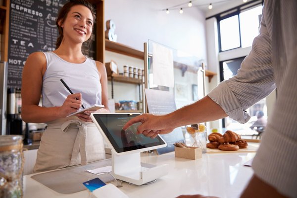 Smiling barista takes customer order