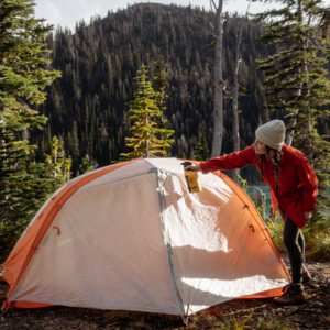 Individual spraying permethrin on tent