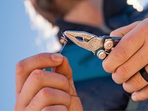 Photo shows person using Skeletool CX on a fishing hook