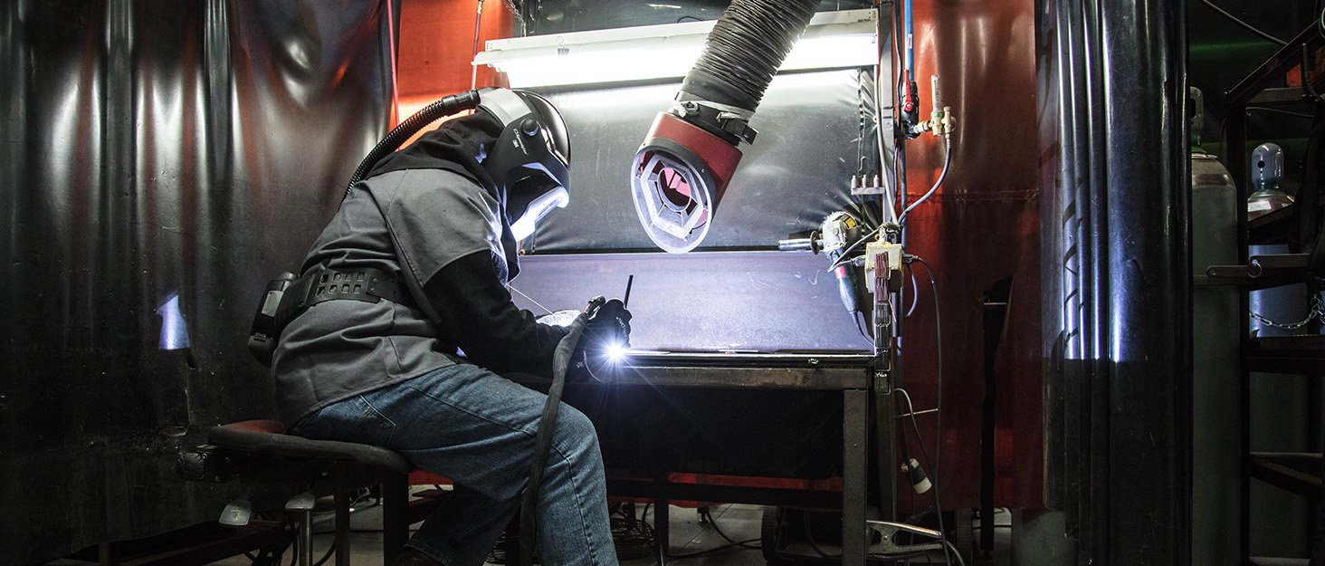 Welder at workstation wearing 3M Speedglas welding helmet