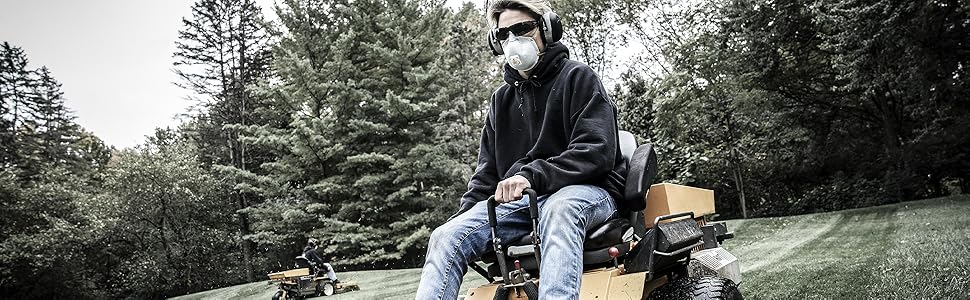 Man mowing lawn while wearing respirator