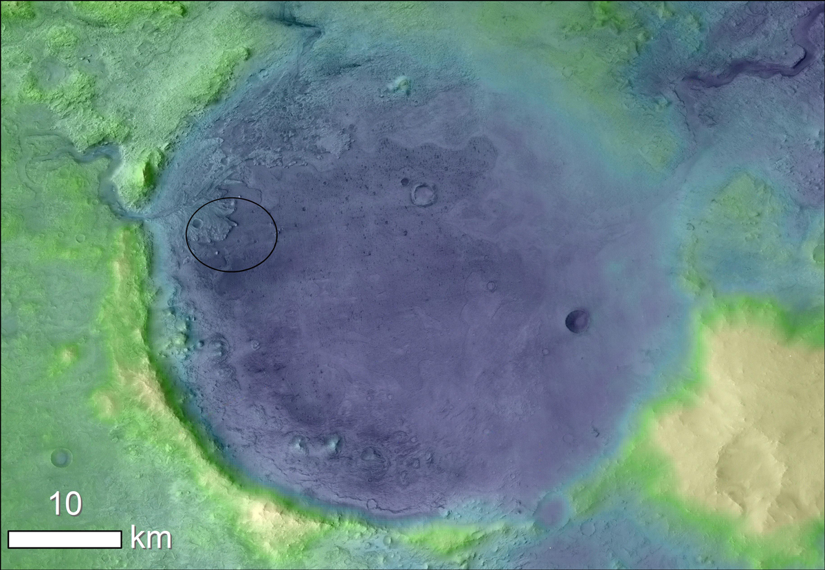 A false-color satellite image of Jezero Crater is green and yellow around the edges with a large blue circular crater in the middle.