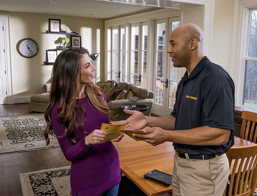 Stanley Steemer technician talking to a happy customer in their home. 