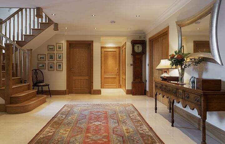 Area rug laying on a natural stone floor next to a staircase.