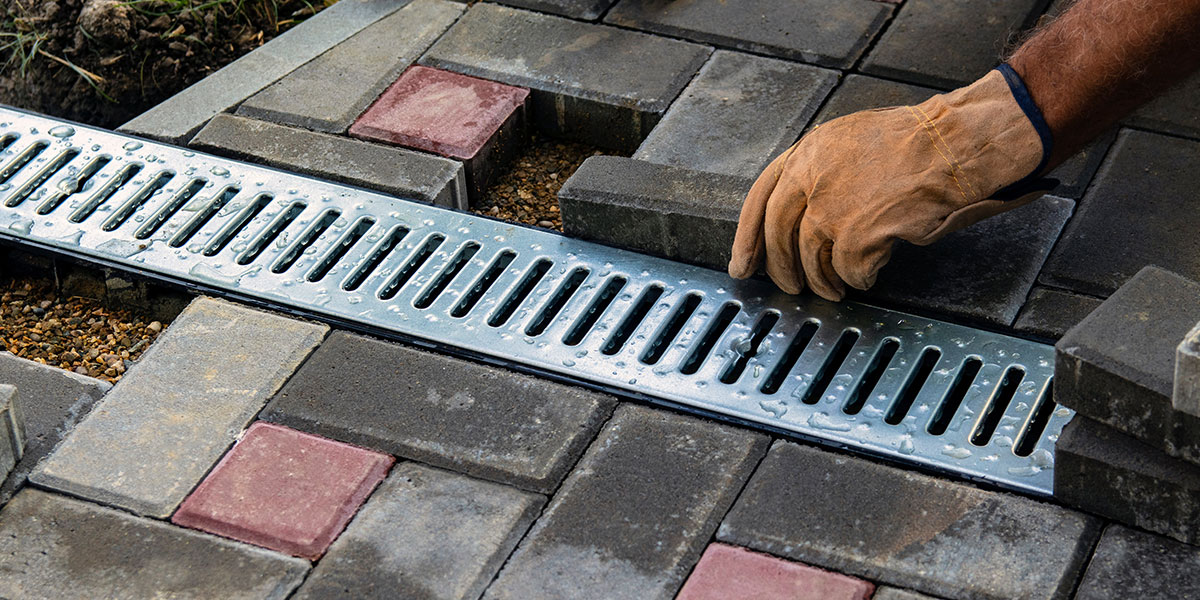 Contractor constructing a brick walkway with a drain - Masonry Waterproofing and Drainage Masters in Portland OR