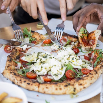 Come si mangia la pizza: con le mani o con le posate?