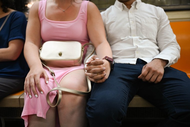 Sara Torres and her husband on the subway in the Financial District on June 24.