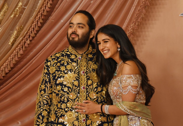 Anant Ambani, son of Indian businessman Mukesh Ambani, and his fiancée, Radhika Merchant, pose for a photo on the red carpet during the sangeet ceremony in Mumbai.