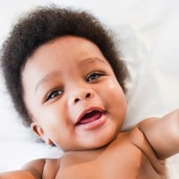 African American baby boy laying on bed