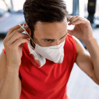 Man putting on a face mask at the gym.