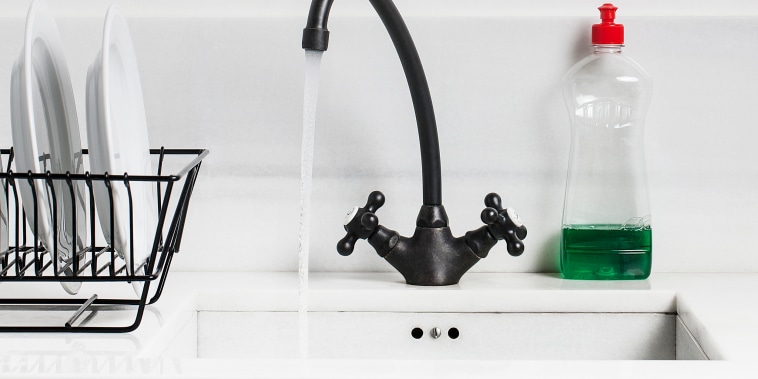 A sink, water tap and dish soap in a kitchen.