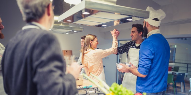 Image: Young couple enjoying cooking class in kitchen