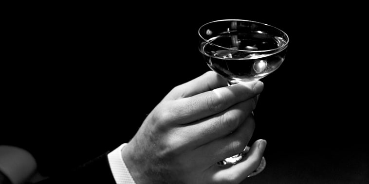 Image: A man raises a glass to toast.