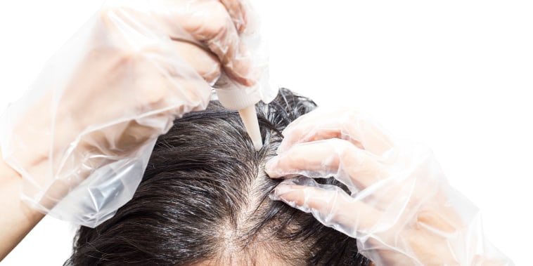 Woman dyeing her hair, isolated on white