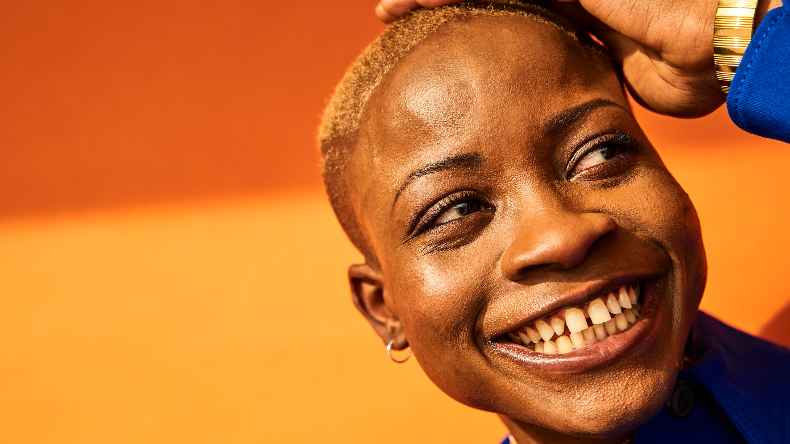 colorful portrait of a woman with short hair in front of an orange background