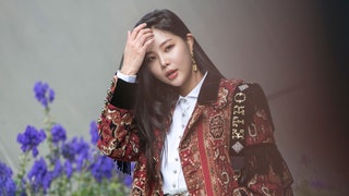 woman at Seoul Fashion Week with effortless makeup and ornate jacket on