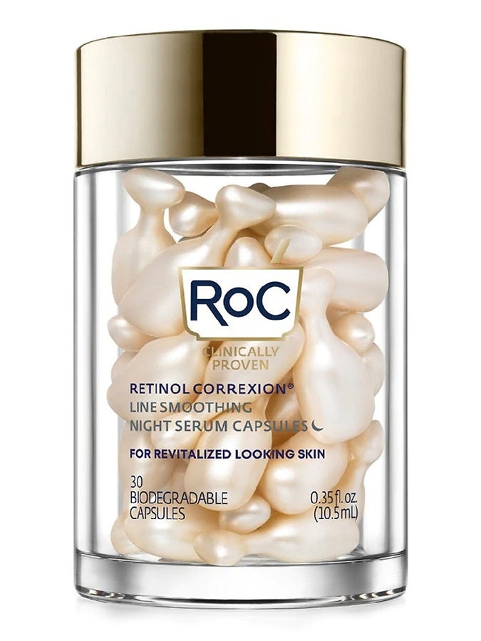 A transparent jar of gold RoC Retinol Correxion Line Smoothing Night Serum Capsules on white background