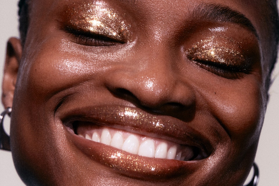 Close up of woman's face with gold makeup