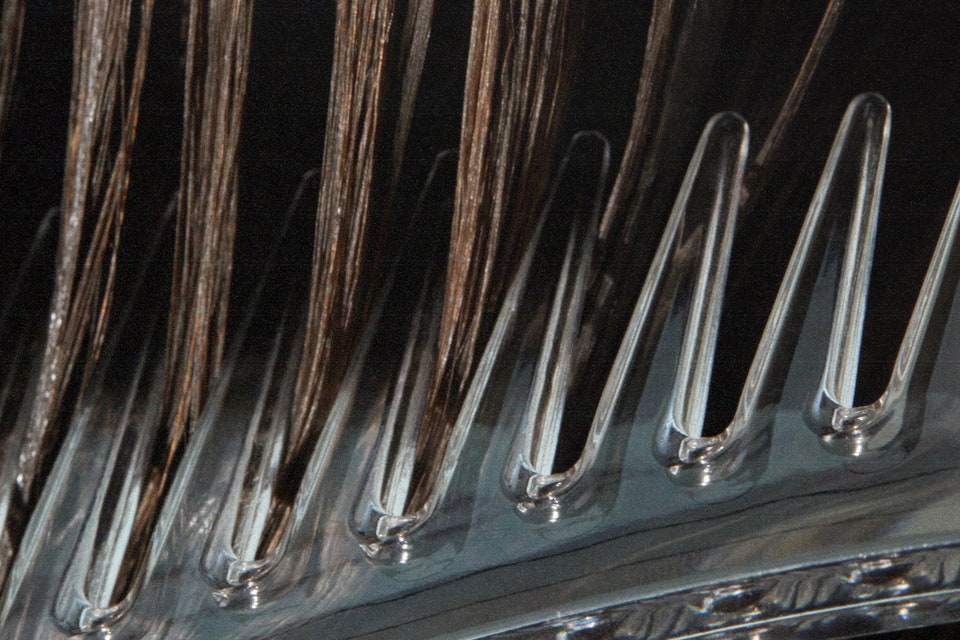 closeup of hair being brushed with comb