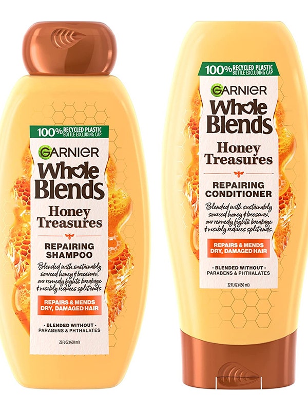 Garnier Whole Blends Honey Treasures Repairing Shampoo and Conditioner two yellow bottles with bronze caps on white background