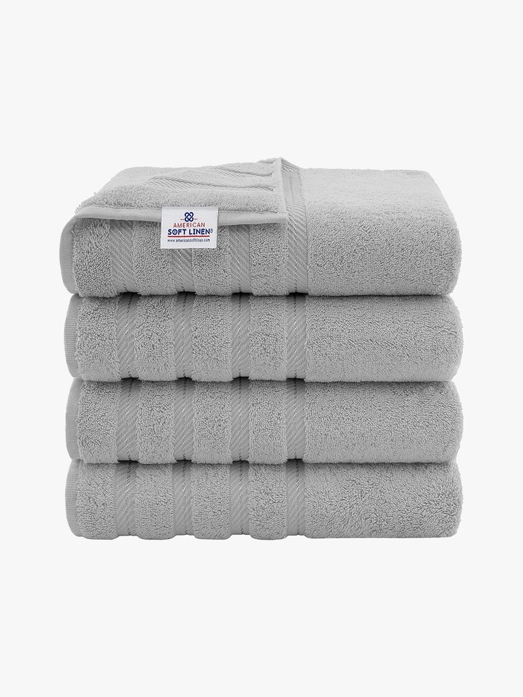 American Soft Linen Luxury 4-Piece Bath Towel Set stack of four folded gray towels on light gray background