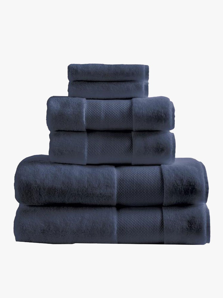 A stack of six navy Frontgate Resort Collection towels on light gray background