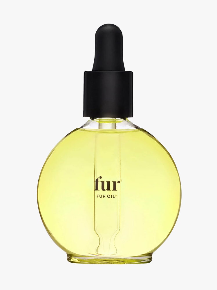 Fur Oil round bottle of yellow body oil with black dropper cap on light gray background