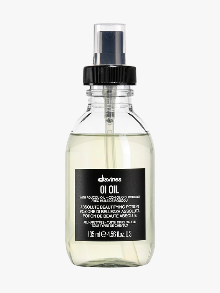 Davines Oi Oil in branded clear glass bottle with black pump on light gray background