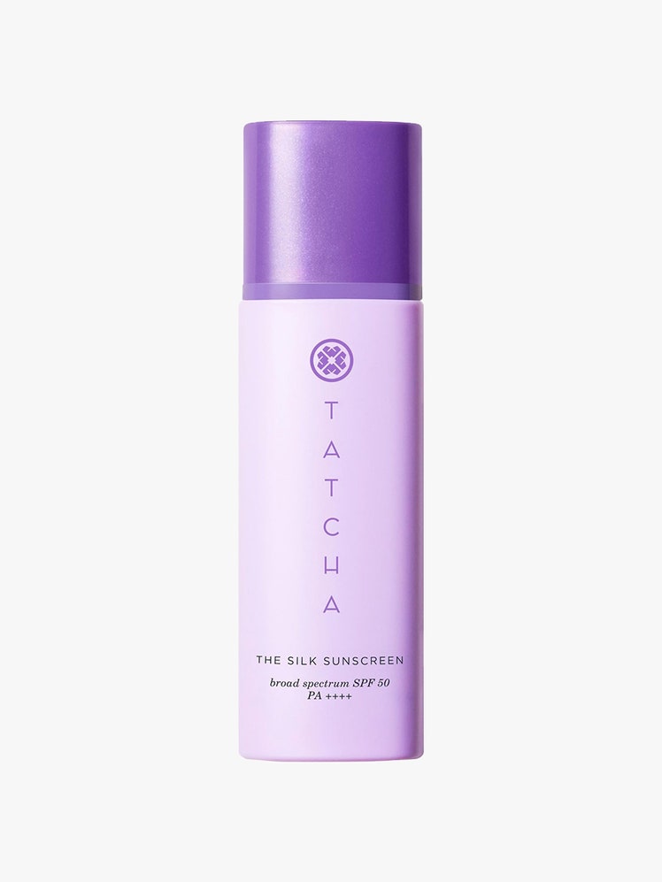 Tatcha The Silk Sunscreen: A lavender-colored bottle with dark purple text and cap on a light gray background