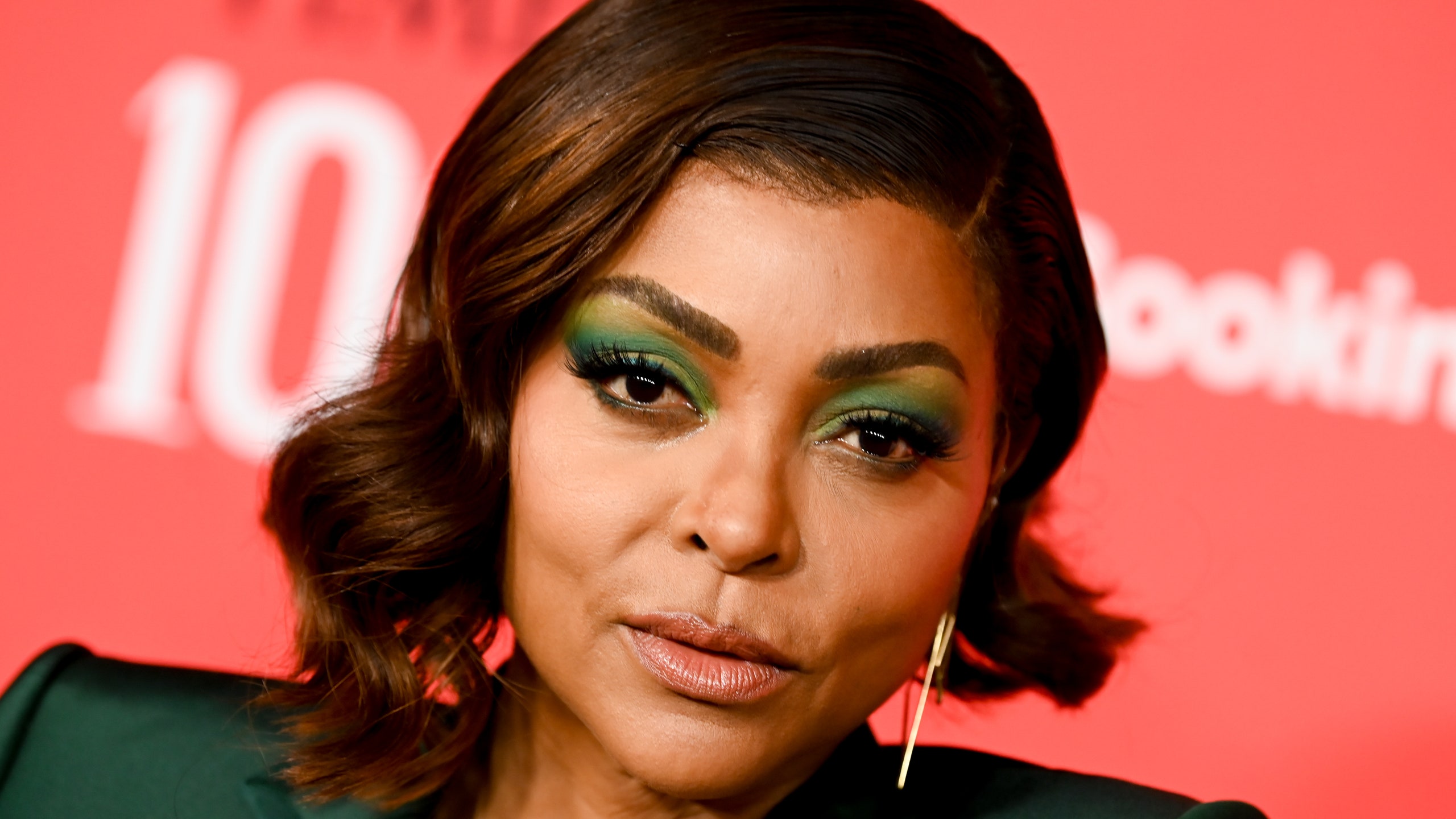 Taraji P. Henson poses in a green blazer and green eye shadow.