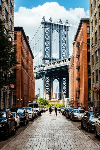 city street with bridge in background