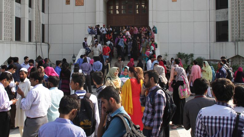 People stand outside their offices in Lahore, Pakistan.