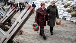 Faithful walk between sandbags and hedgehog anti-tank barricades to attend a blessing of traditional Easter food baskets on Holy Saturday, amid Russia's invasion of Ukraine, in Zhytomyr, Ukraine April 23, 2022. REUTERS/Viacheslav Ratynskyi     TPX IMAGES OF THE DAY