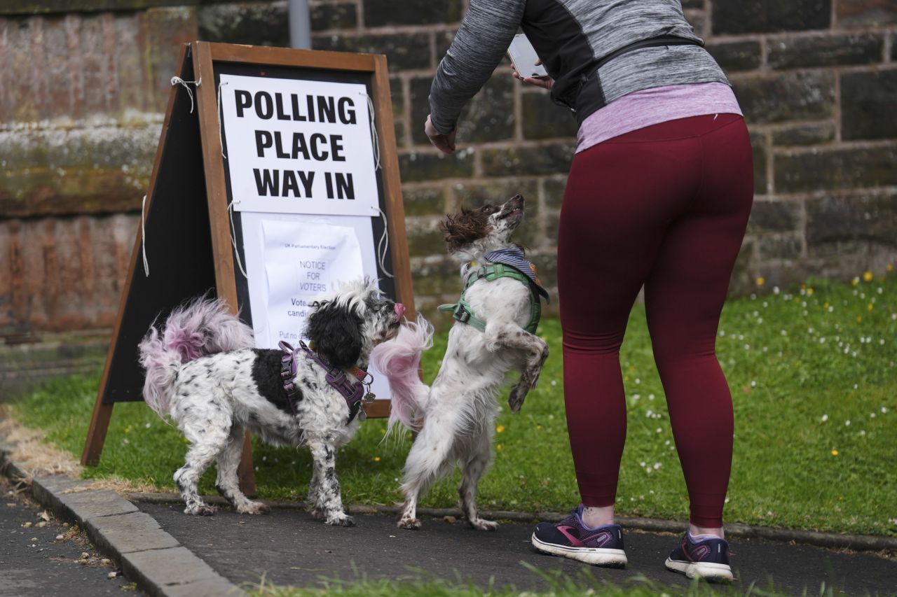 A voter wrangles their dogs at a polling station in Glasgow, Scotland. 