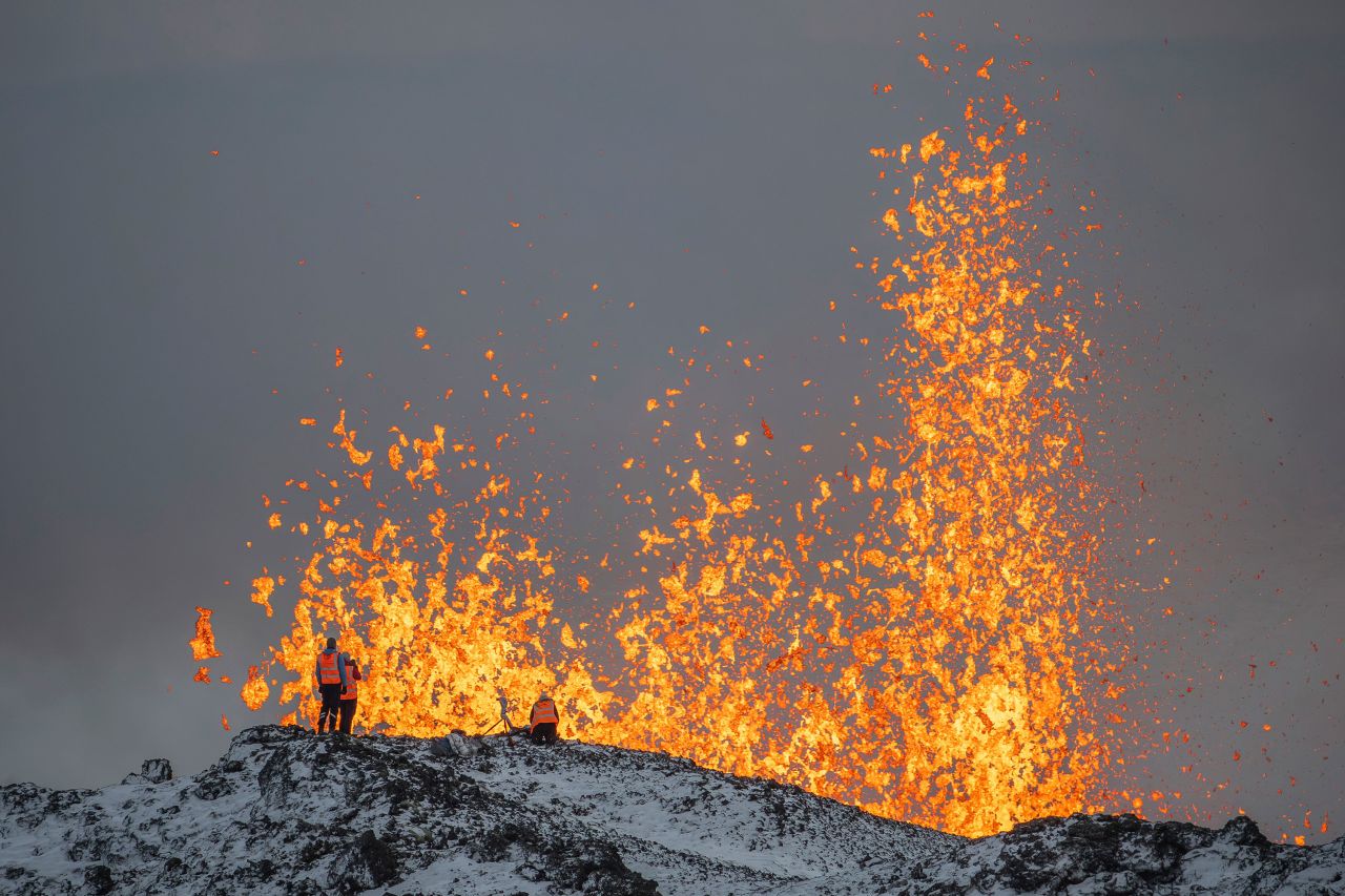 Scientists with the University of Iceland take measurements and samples from the ridge of an active part of the fissure on Tuesday.