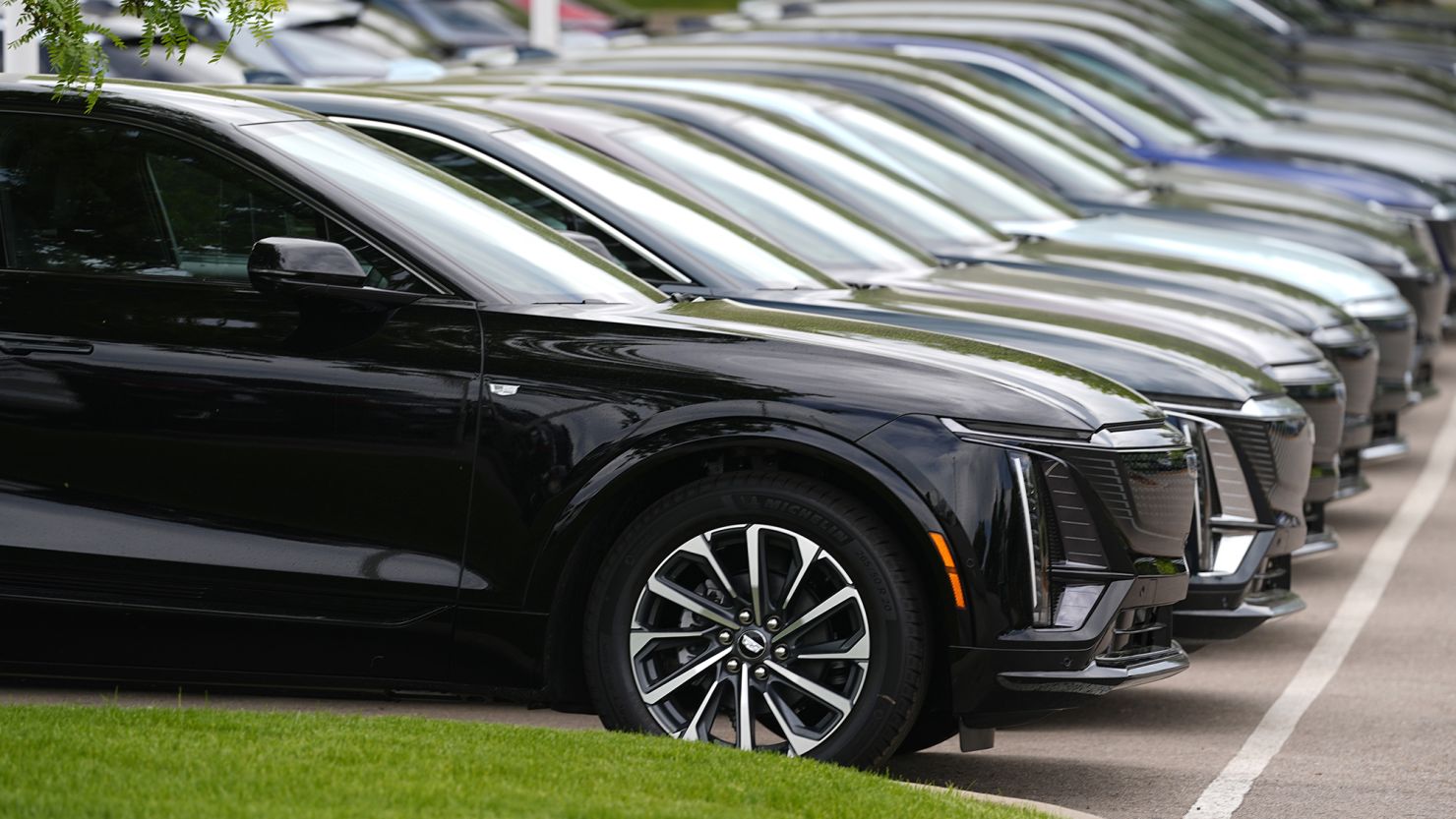Vehicles sit in a row outside a dealership, June 2, 2024, in Lone Tree, Colo.
